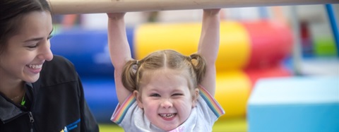 Toddler with coach at gymnastics class